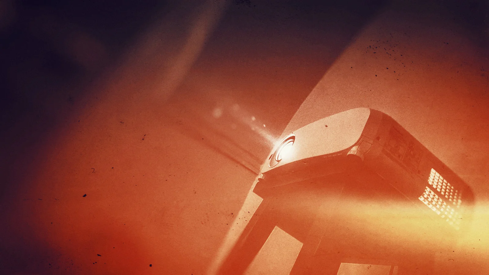 Projektor mit Lichtstrahl,  in einem orangefarbenen Raum