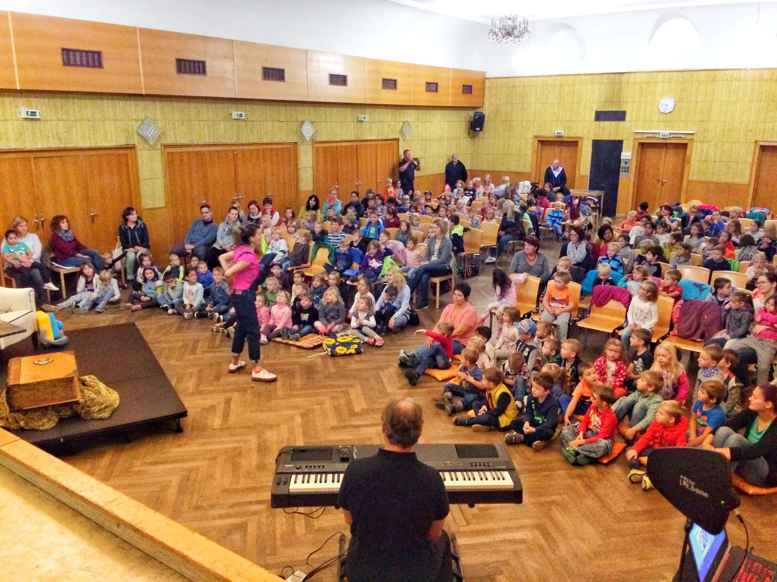 Auftritt in einem Turnsaal voller Volksschulkinder.